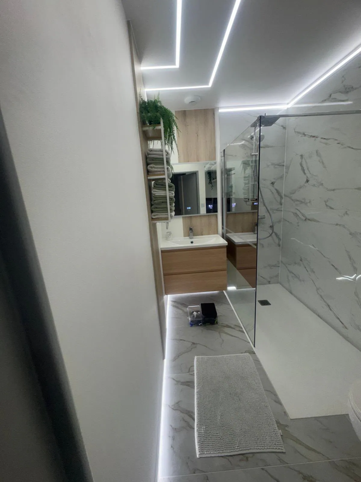 Salle de bain rénovée avec douche et meuble vasque